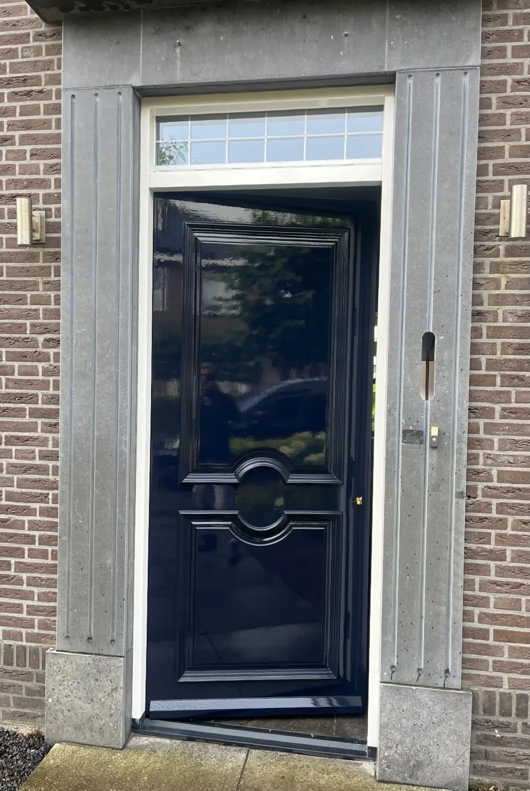 Een klassieke voordeur met een glanzende donkerblauwe afwerking.